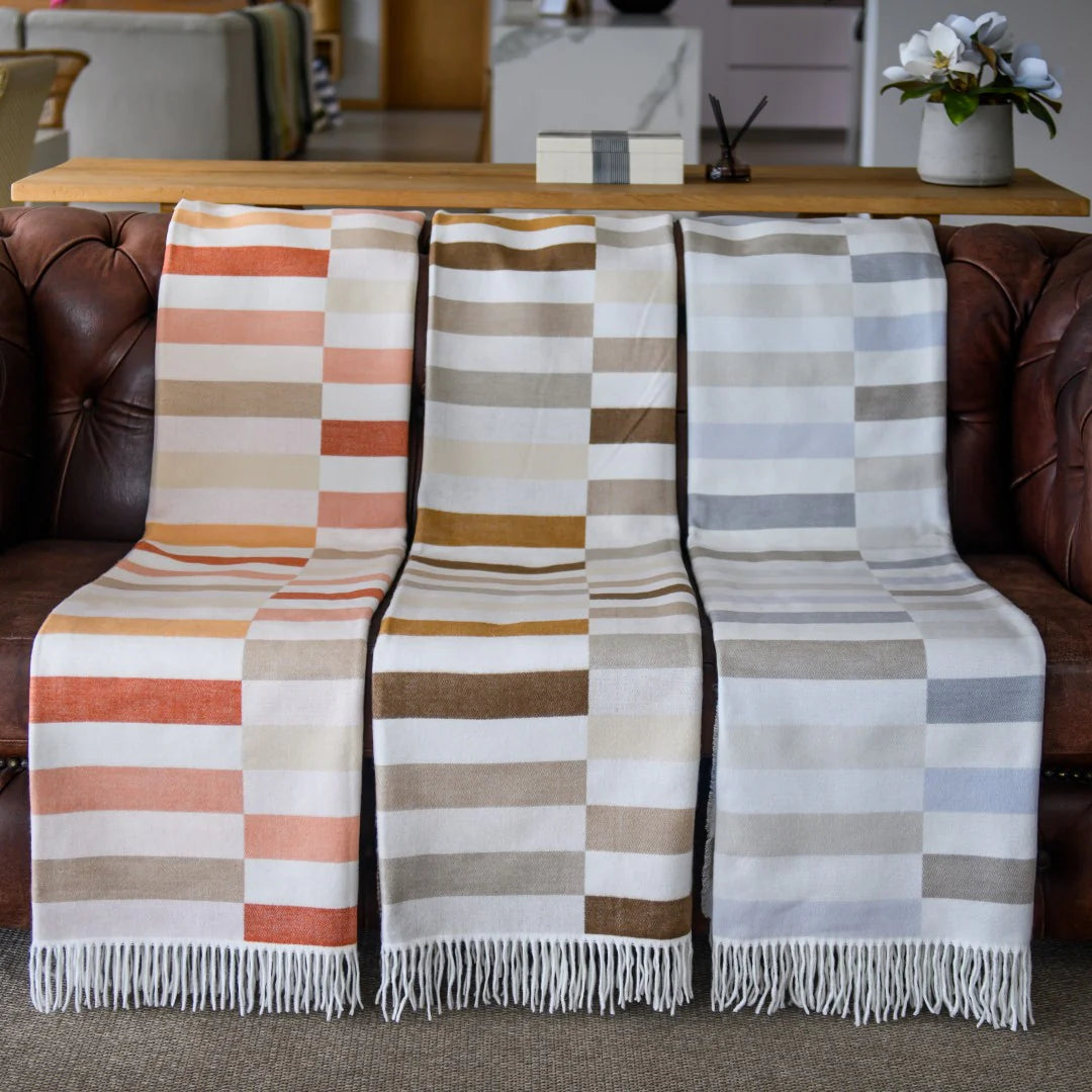 Haven & Earth Bella Vita Sequence throws draped over a sofa in a living room setting.