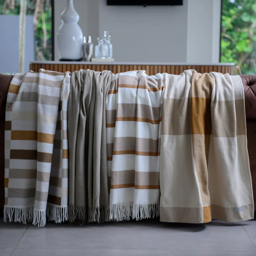 Bella Vita Sequence Cinnabar/Dark Beige throw draped over a sofa in a living room setting.