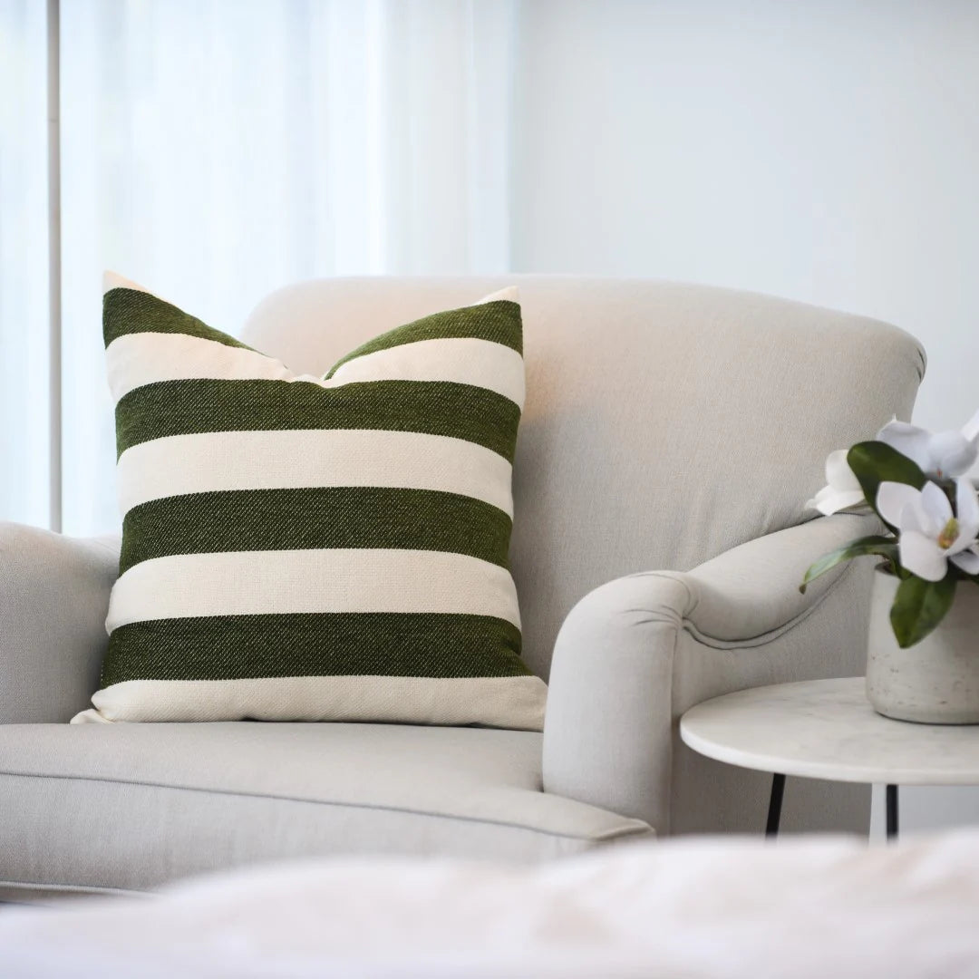 Protea Chenille Scatter Cushion in Hunter and Natural, 55x55 cm, soft chenille texture, arranged on a lounge chair.