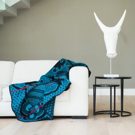 The Kharetsa is named after the spiral aloe which is only found in the Maluti Mountains of Lesotho. The aloe is prominently featured in the centre of the design. It is surrounded by iconic Basotho hat and shield motifs.  Basotho blanket