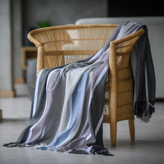 Protea Pinstripe Sunset throw in Black/Steel – bold striped design with hand-knotted fringes.