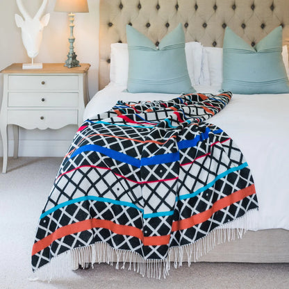 The Xhosa Ithumbu Throw in Black and Natural features bold traditional motifs in timeless monochrome. A cultural statement piece with modern minimalism.